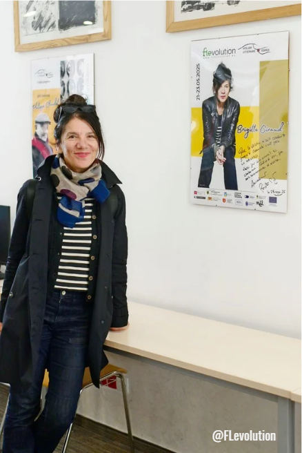 Brigiite Giraud à côté de l'affiche dédicacé